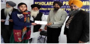 A student is receiving scholarship check from Sikh Human Development Foundation