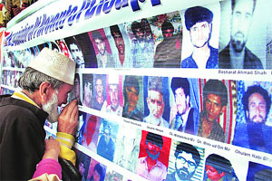 A Srinagar father looks at a photo of his missing son (Mass Graves Case)